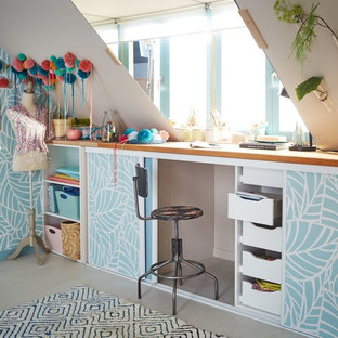 Cette photo montre un bureau atelier tendance de taille moyenne avec un mur bleu, un sol en bois clair, aucune cheminée, un bureau intégré et un sol beige.