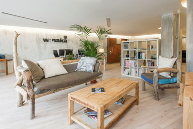 Cette image montre une salle de séjour minimaliste avec une bibliothèque ou un coin lecture, un mur gris, parquet clair et aucune cheminée.