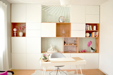 Cette image montre un bureau design avec une bibliothèque ou un coin lecture et parquet clair.