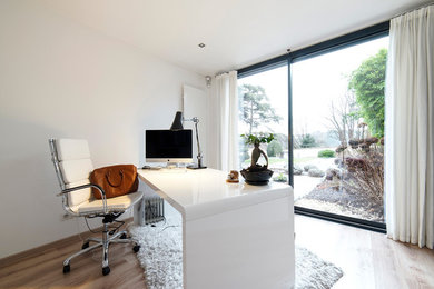 Cette image montre un bureau design de taille moyenne avec un mur blanc, parquet clair, aucune cheminée et un bureau indépendant.