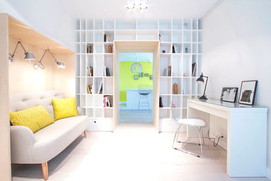 Inredning av ett minimalistiskt stort hemmabibliotek, med vita väggar, ett fristående skrivbord och ljust trägolv