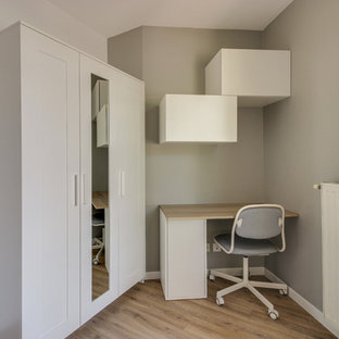 Idée de décoration pour un bureau nordique avec un mur gris, un sol en bois brun, un bureau intégré et un sol marron.