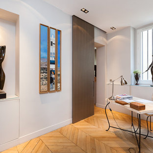 Idée de décoration pour un bureau design avec un mur blanc, un sol en bois clair et un bureau indépendant.
