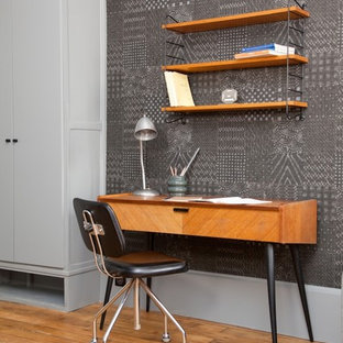 Aménagement d'un bureau contemporain avec un mur gris, un sol en bois brun et un bureau indépendant.