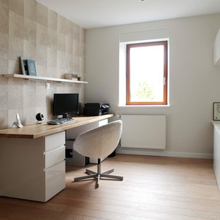Modernes Arbeitszimmer mit Arbeitsplatz, bunten Wänden, braunem Holzboden, freistehendem Schreibtisch und orangem Boden in Rennes