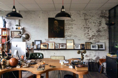 Imagen de sala de manualidades industrial extra grande con suelo de madera en tonos medios, escritorio independiente y suelo marrón