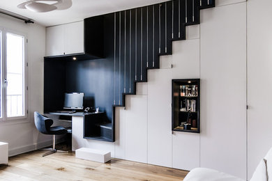 Immagine di un piccolo ufficio design con scrivania incassata, pareti bianche e pavimento in legno massello medio