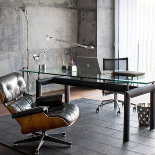 Réalisation d'un bureau design de taille moyenne avec un sol en bois foncé, un bureau indépendant et un mur gris.