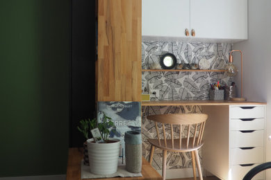 Ejemplo de despacho nórdico con paredes verdes, suelo de madera clara y papel pintado