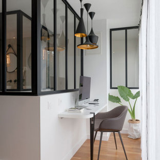 Exemple d'un petit bureau tendance avec un mur blanc, un bureau intégré, un sol en bois brun et un sol marron.