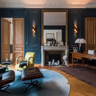 Idée de décoration pour un bureau tradition avec un mur bleu, un sol en bois clair, une cheminée standard, un bureau indépendant et un sol marron.