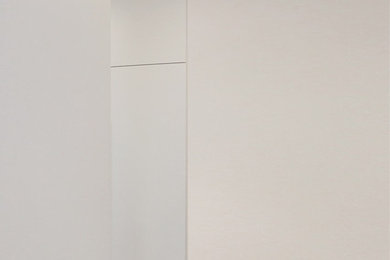 Imagen de estudio actual de tamaño medio con paredes blancas, suelo de cemento, escritorio independiente y suelo beige