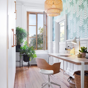 Klassisk inredning av ett litet hemmabibliotek, med blå väggar, mörkt trägolv, ett fristående skrivbord och brunt golv