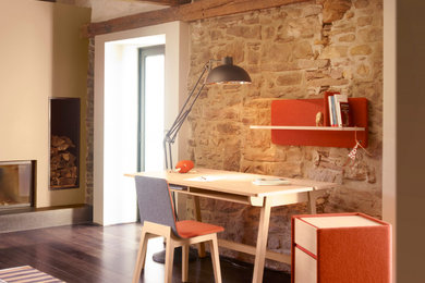 Mittelgroßes Modernes Arbeitszimmer mit Arbeitsplatz, beiger Wandfarbe, dunklem Holzboden, Kamin und freistehendem Schreibtisch in Bordeaux