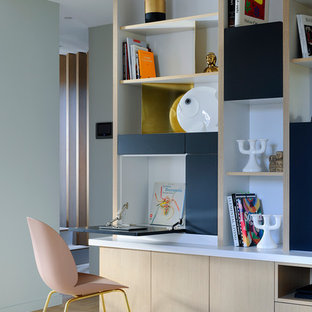 Cette image montre un bureau design avec un mur multicolore, un sol en bois clair et un bureau intégré.