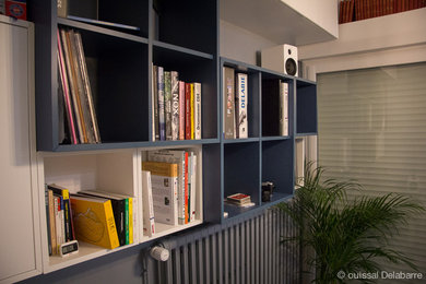 Imagen de despacho actual de tamaño medio sin chimenea con biblioteca, paredes grises, suelo laminado, escritorio empotrado y suelo gris