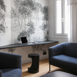 Exemple d'un bureau tendance de taille moyenne avec un mur multicolore, un sol en bois clair, un bureau intégré et un sol beige.