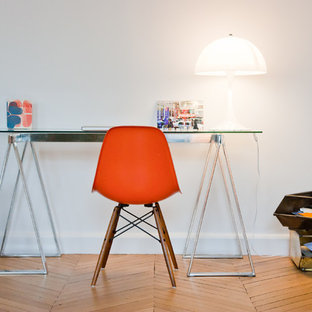 Aménagement d'un petit bureau contemporain avec un bureau indépendant, un mur blanc et un sol en bois brun.