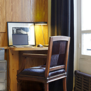 Cette photo montre un bureau tendance avec un bureau intégré, un mur blanc et un sol en bois brun.