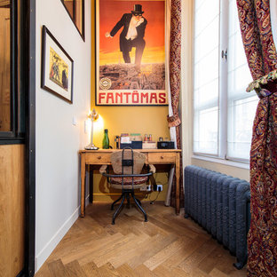 Cette photo montre un bureau industriel avec un mur jaune, un sol en bois brun, aucune cheminée, un bureau indépendant et un sol marron.