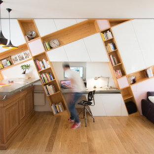 Cette image montre un bureau design avec un sol en bois brun, un bureau intégré et un sol marron.
