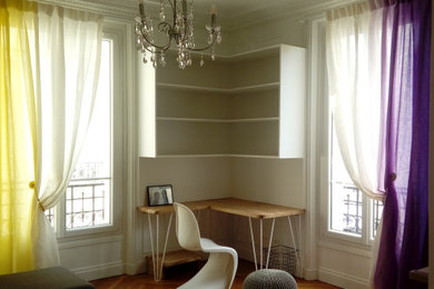パリにある低価格の中くらいなモダンスタイルのおしゃれな書斎 (白い壁、淡色無垢フローリング、コーナー設置型暖炉、石材の暖炉まわり、造り付け机、ベージュの床) の写真