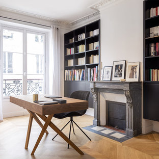 Réalisation d'un grand bureau tradition avec un mur blanc, un sol en bois clair, une cheminée standard, un manteau de cheminée en pierre, un bureau indépendant et un sol beige.