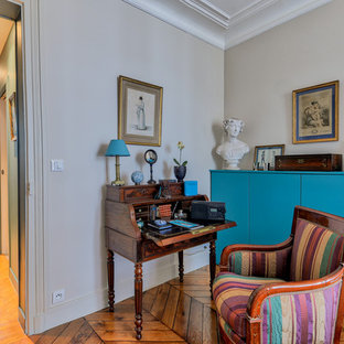 Idée de décoration pour un petit bureau design avec aucune cheminée, un bureau indépendant, un mur beige et un sol en bois brun.