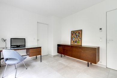 Klassisk inredning av ett mellanstort arbetsrum, med vita väggar, klinkergolv i keramik, ett inbyggt skrivbord och grått golv