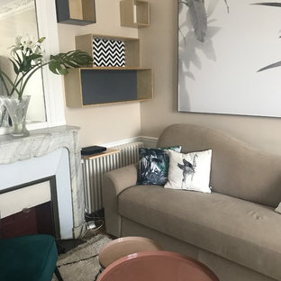 Bild på ett mellanstort tropiskt hemmabibliotek, med beige väggar, ljust trägolv, en standard öppen spis, en spiselkrans i trä och brunt golv