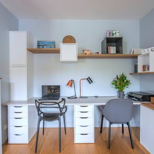 Exemple d'un grand bureau tendance avec un mur gris et un bureau intégré.