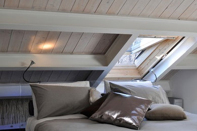 Ispirazione per una camera da letto stile loft moderna di medie dimensioni con pareti bianche e parquet chiaro