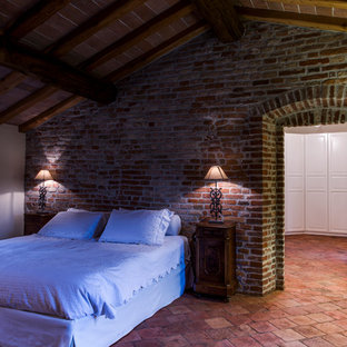 Ejemplo de dormitorio de estilo de casa de campo con paredes beige, suelo de baldosas de terracota y suelo rojo
