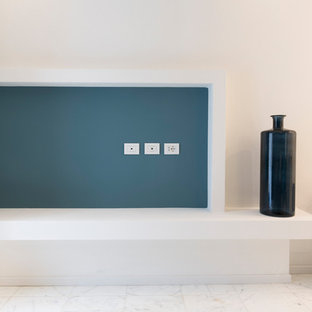 Imagen de dormitorio tipo loft, actual, pequeño, con paredes azules, suelo de mármol y suelo blanco