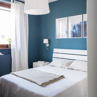 Foto di una piccola camera matrimoniale design con pareti blu, pavimento in gres porcellanato e pavimento marrone