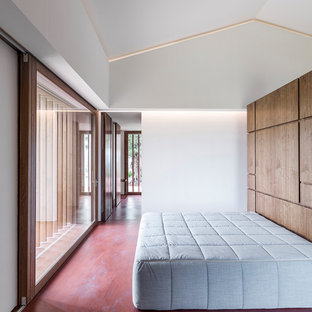Foto de habitación de invitados actual, grande, con suelo de cemento y suelo rojo