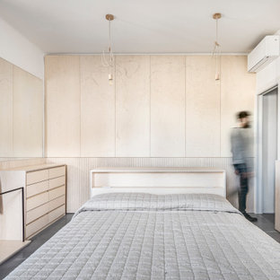 Foto di una camera matrimoniale design di medie dimensioni con pareti bianche, pavimento in cemento e pavimento grigio