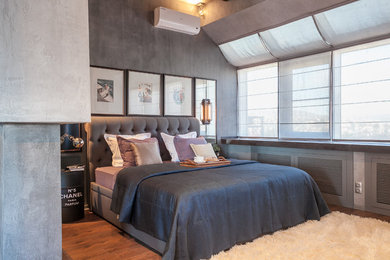 Foto de habitación de invitados industrial con paredes grises, suelo de madera en tonos medios y suelo marrón