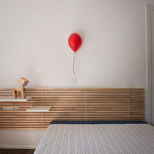 Imagen de dormitorio contemporáneo, de tamaño medio, con paredes blancas, suelo de madera en tonos medios, chimeneas suspendidas, marco de chimenea de yeso y suelo marrón
