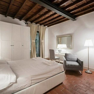 Imagen de dormitorio principal, minimalista, con paredes blancas, suelo de ladrillo y suelo rojo