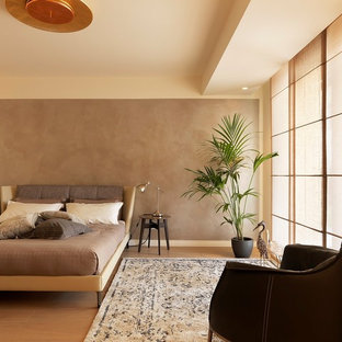 Immagine di una camera matrimoniale design con pareti marroni, parquet chiaro e pavimento beige