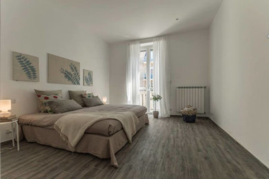 Immagine di una camera da letto design con pavimento in gres porcellanato, pareti bianche e nessun camino