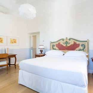 Ispirazione per una camera da letto mediterranea con pareti blu, parquet chiaro e pavimento beige