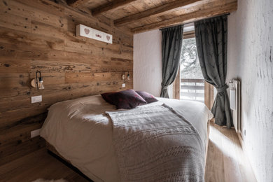 Ejemplo de dormitorio rural de tamaño medio con paredes blancas y suelo beige