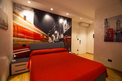Immagine di una piccola camera degli ospiti moderna con pareti multicolore, parquet chiaro e pavimento marrone