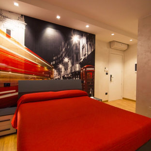 Ejemplo de habitación de invitados moderna, pequeña, con paredes multicolor, suelo de madera clara y suelo marrón