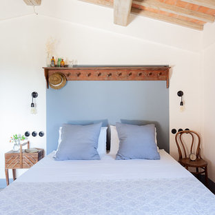 Ispirazione per una camera da letto country con pareti bianche e pavimento multicolore