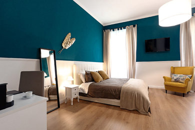 ローマにある広いトラディショナルスタイルのおしゃれな主寝室 (青い壁、ラミネートの床、暖炉なし) のインテリア