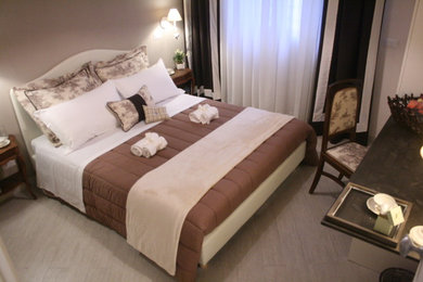 Modelo de dormitorio romántico de tamaño medio con paredes grises, suelo de baldosas de porcelana y suelo beige