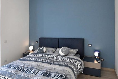 Ejemplo de dormitorio principal nórdico pequeño con paredes azules, suelo de baldosas de porcelana y suelo beige